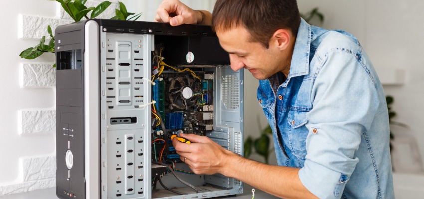 Un technicien PC & réseaux est en train de réparer une tour d'ordinateur