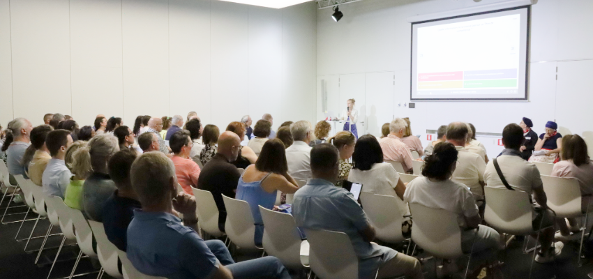 des personnes assises devant une projection d'une présentation sur la thématique de la journée des Centres 2026